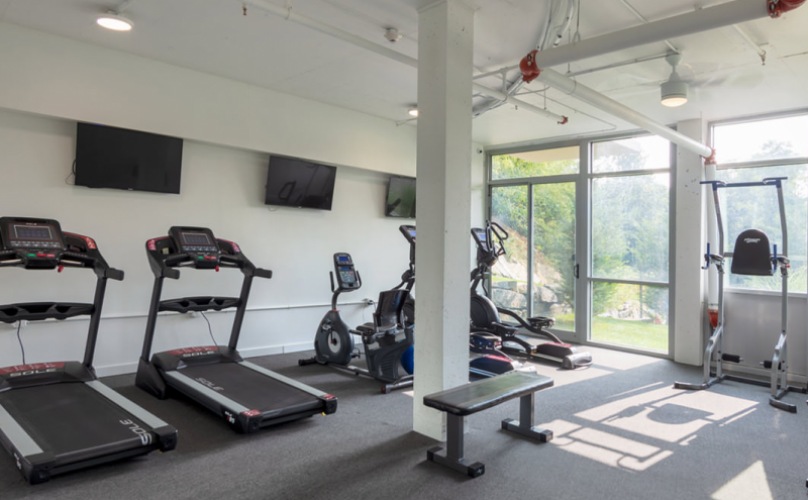 open fitness center with overhead lighting throughout