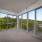 huge panel windows surround living room providing beautiful woodland views